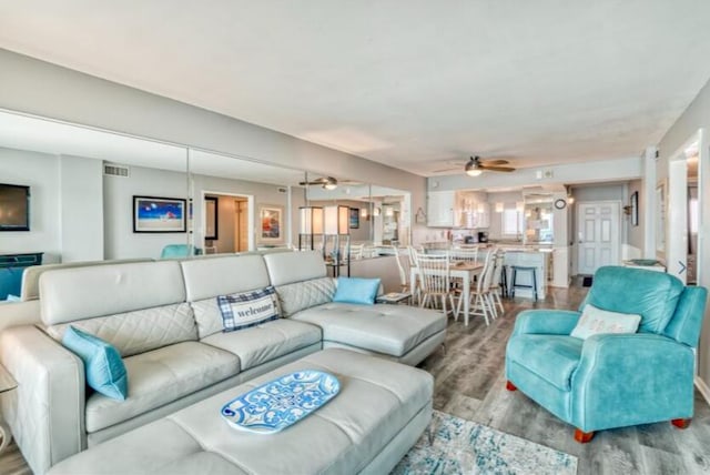 living room featuring ceiling fan and light hardwood / wood-style floors