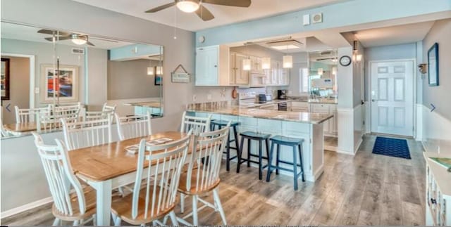 dining space with ceiling fan and light hardwood / wood-style floors