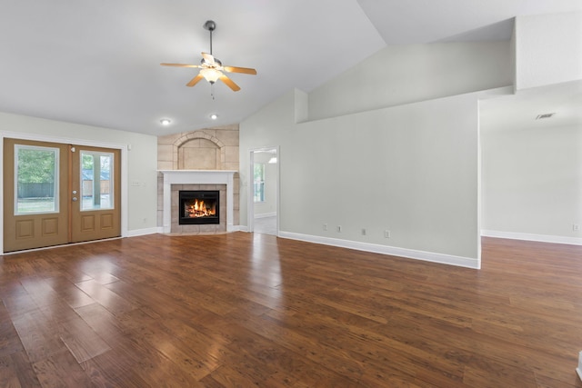 unfurnished living room with high vaulted ceiling, dark hardwood / wood-style floors, ceiling fan, and a tile fireplace