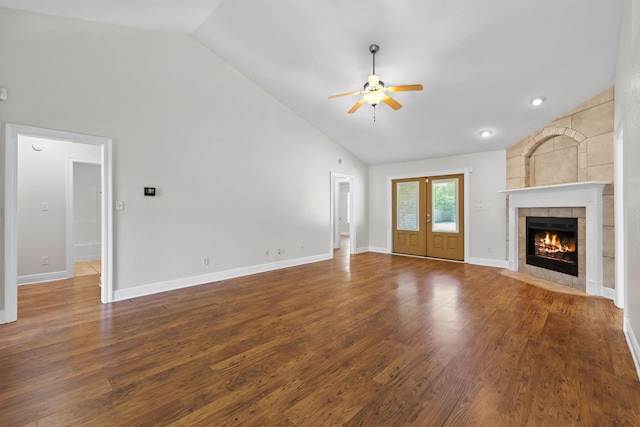 unfurnished living room with a fireplace, french doors, ceiling fan, and dark wood-type flooring