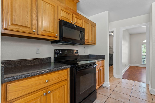 kitchen with light tile patterned floors and black appliances