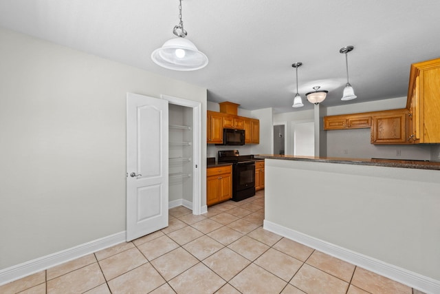 kitchen featuring light tile patterned floors, black appliances, and decorative light fixtures