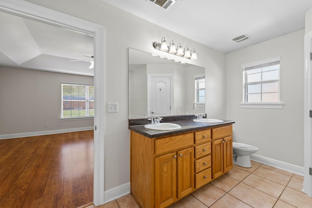 bathroom featuring hardwood / wood-style floors, vanity, toilet, and ceiling fan