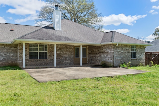 rear view of property featuring a lawn and a patio area