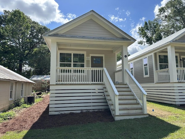 view of front of home with a porch and central AC