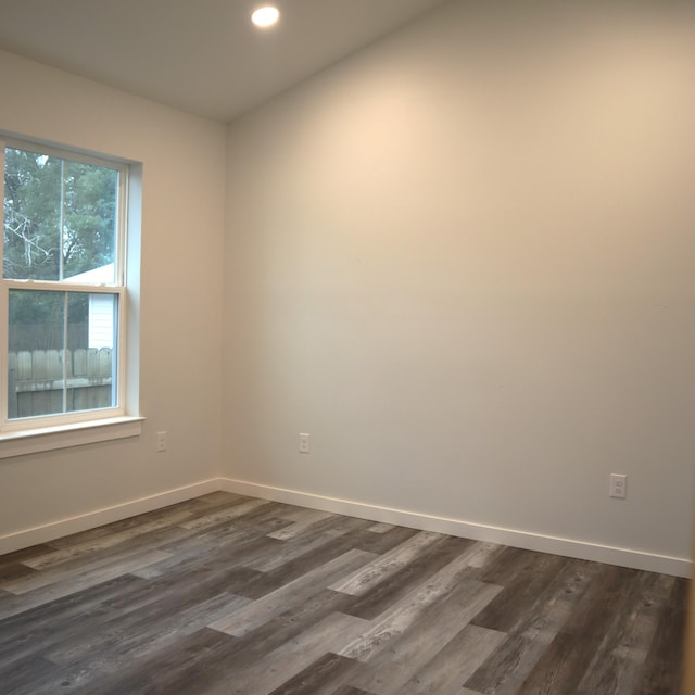 unfurnished room with dark wood-type flooring