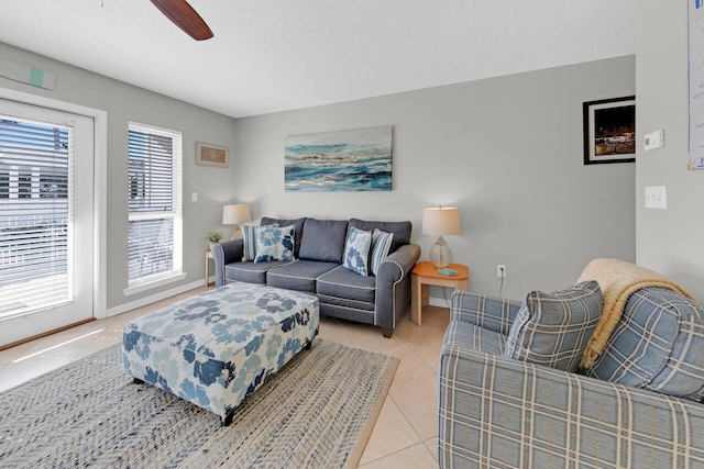 living room featuring ceiling fan, light tile patterned floors, and a textured ceiling