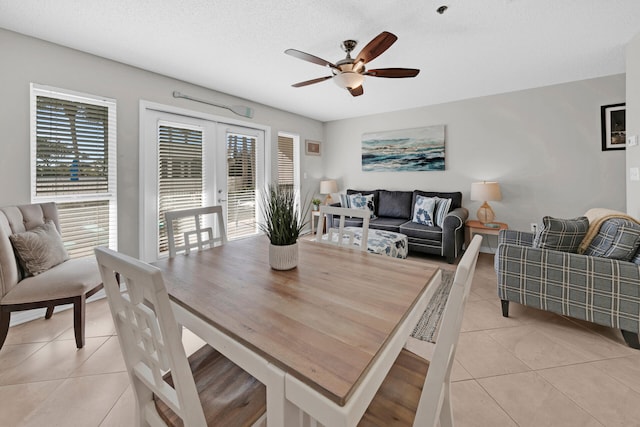 tiled dining room featuring ceiling fan and a textured ceiling