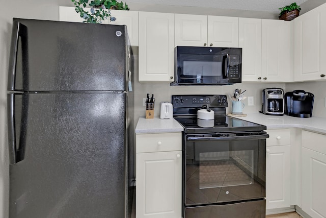 kitchen featuring a textured ceiling, white cabinetry, and black appliances