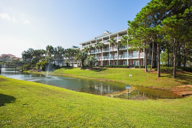 view of community featuring a lawn and a water view