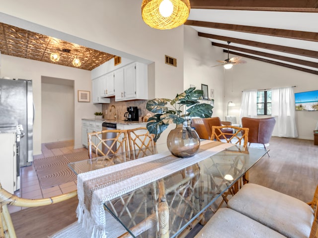 dining room with vaulted ceiling with beams, ceiling fan, sink, and light hardwood / wood-style floors