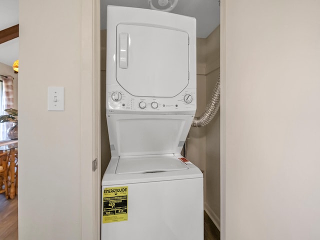 laundry area featuring stacked washing maching and dryer and hardwood / wood-style flooring