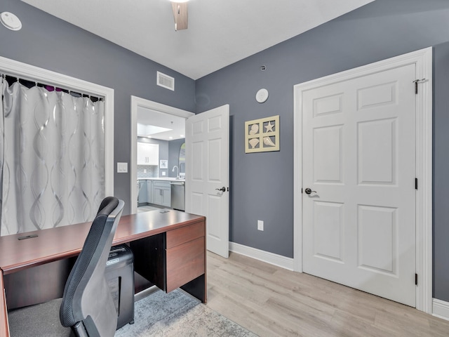 home office featuring ceiling fan, light hardwood / wood-style floors, and sink