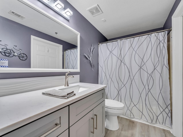 bathroom with curtained shower, vanity, wood-type flooring, and toilet