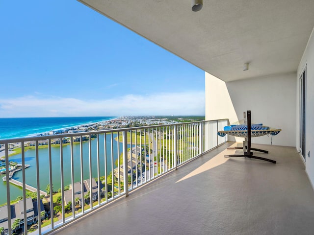 balcony with a water view and a view of the beach