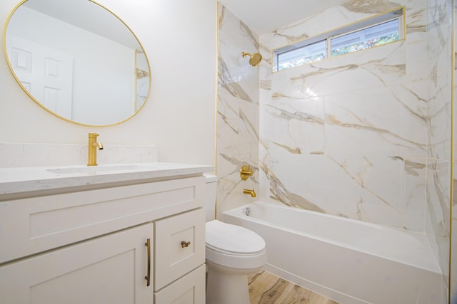 full bathroom with hardwood / wood-style floors, tiled shower / bath combo, toilet, and vanity