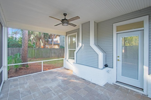 unfurnished sunroom with ceiling fan