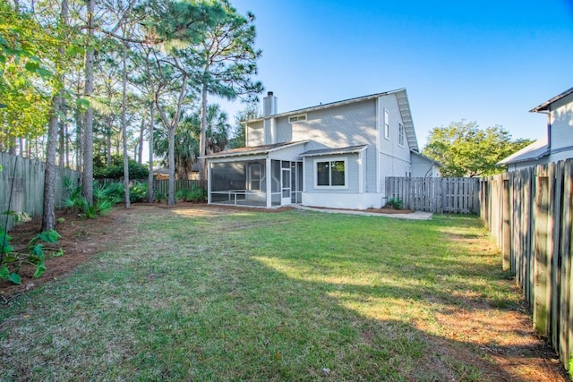 rear view of property featuring a lawn and a sunroom