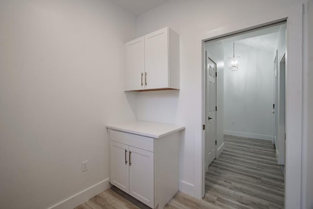 hall featuring light hardwood / wood-style flooring and an inviting chandelier