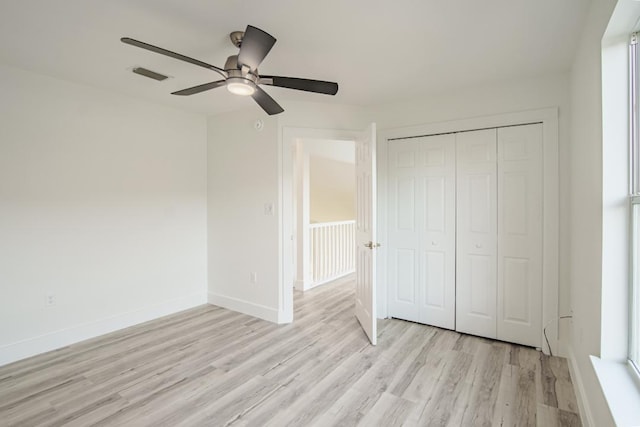 unfurnished bedroom with ceiling fan, a closet, and light hardwood / wood-style floors