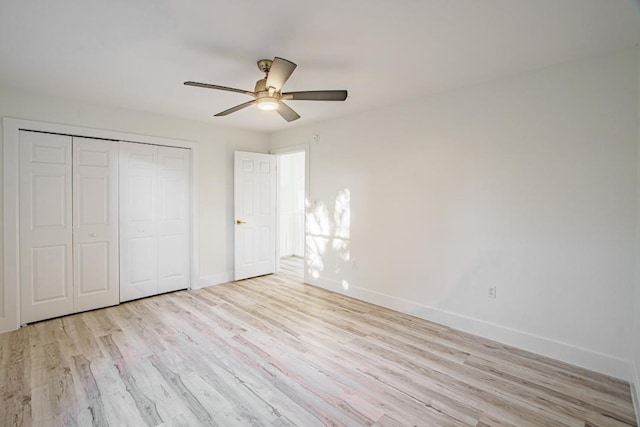 unfurnished bedroom featuring ceiling fan, light hardwood / wood-style floors, and a closet