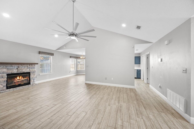 unfurnished living room with ceiling fan, a fireplace, vaulted ceiling, and light wood-type flooring