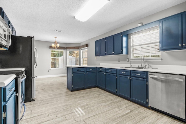 kitchen with stainless steel appliances, blue cabinets, a notable chandelier, and sink