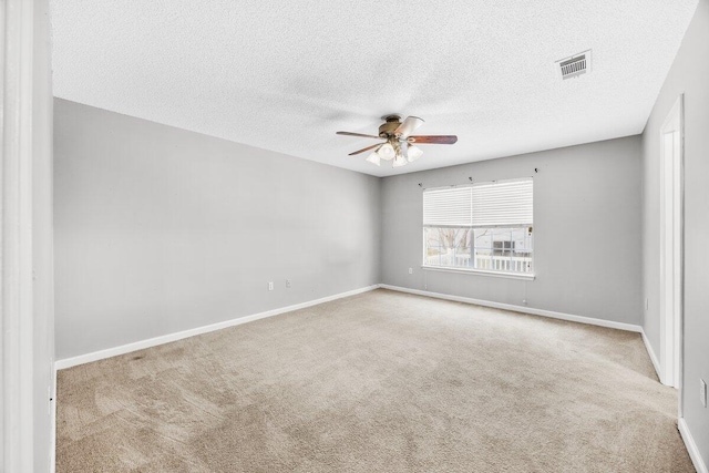 carpeted spare room featuring ceiling fan and a textured ceiling