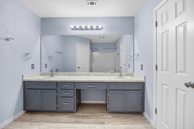 439 Northview Ln, Crestview, FL 32536 - full bath with double vanity, visible vents, walk in shower, wood finished floors, and a sink