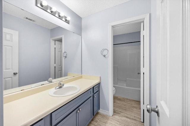 439 Northview Ln, Crestview, FL 32536 - bathroom with vanity, visible vents, wood finished floors, toilet, and a textured ceiling