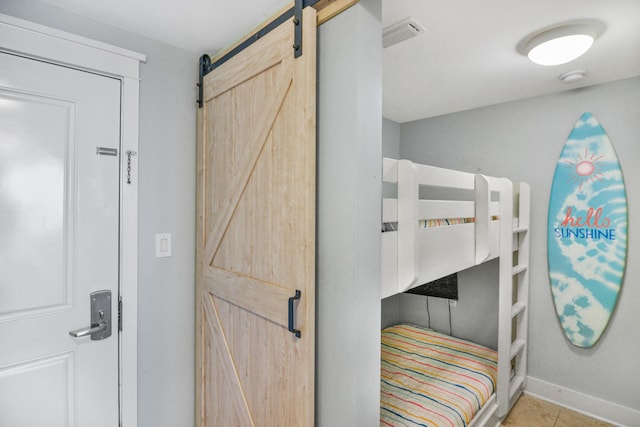 1110 Santa Rosa Blvd Unit C303, Fort Walton Beach, FL 32548 - bedroom with a barn door and tile patterned flooring