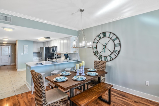 1110 Santa Rosa Blvd Unit C303, Fort Walton Beach, FL 32548 - dining area with crown molding, a chandelier, and light wood-style floors