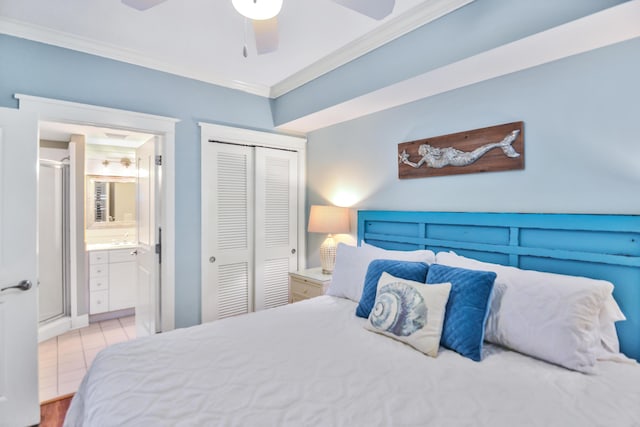 bedroom with crown molding, ensuite bath, ceiling fan, light tile patterned flooring, and a closet