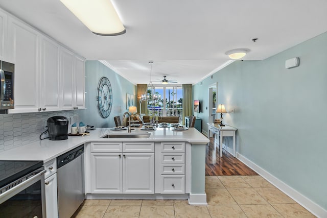 1110 Santa Rosa Blvd Unit C303, Fort Walton Beach, FL 32548 - kitchen featuring appliances with stainless steel finishes, a peninsula, crown molding, a ceiling fan, and white cabinets