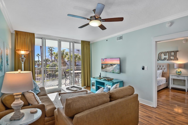 living room with hardwood / wood-style flooring, ceiling fan, and crown molding