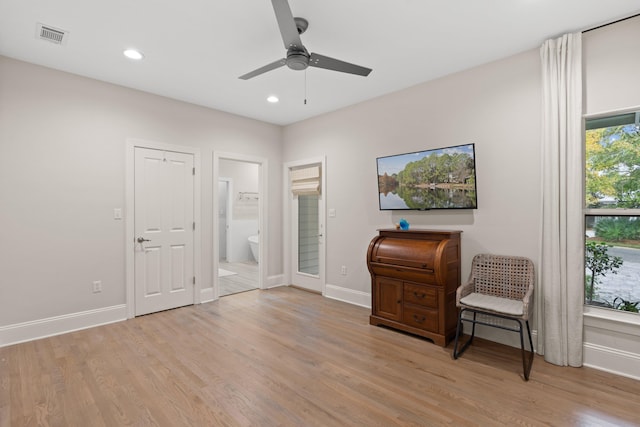 living area featuring light wood-type flooring and ceiling fan