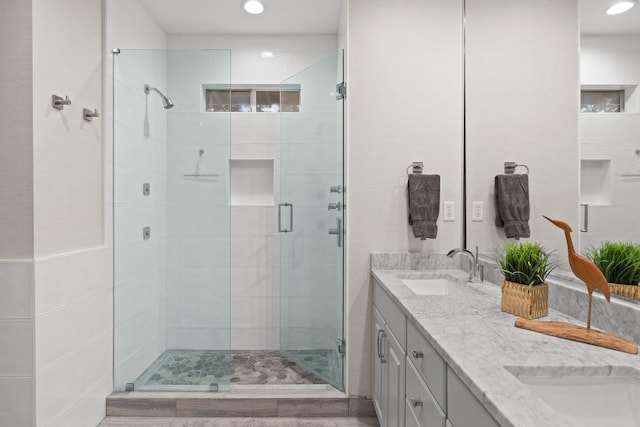 bathroom featuring a shower with door, vanity, and hardwood / wood-style flooring