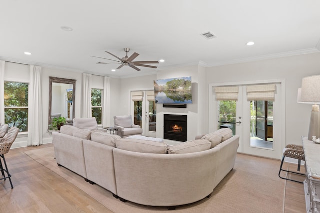 living room featuring french doors, light wood-type flooring, and a healthy amount of sunlight