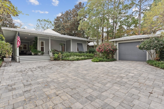 single story home featuring covered porch and a garage