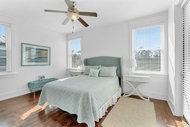 bedroom with ceiling fan, dark wood-type flooring, and multiple windows