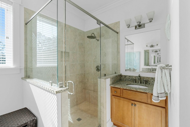 bathroom featuring vanity, a shower with door, and crown molding