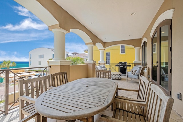 balcony featuring a view of the beach and a water view