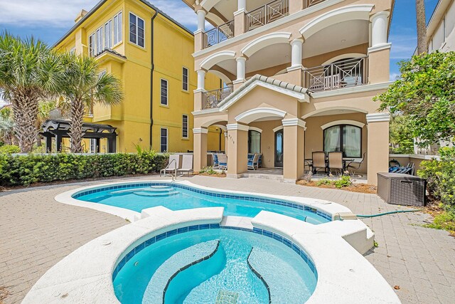 view of pool featuring an in ground hot tub and a patio