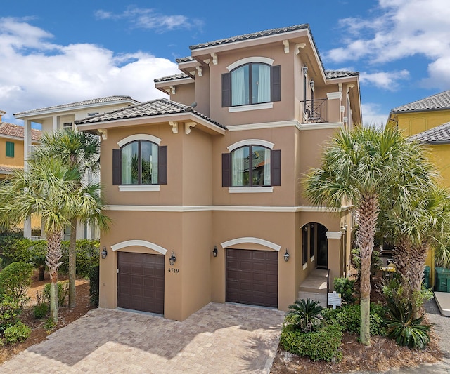 mediterranean / spanish-style house featuring a garage and a balcony