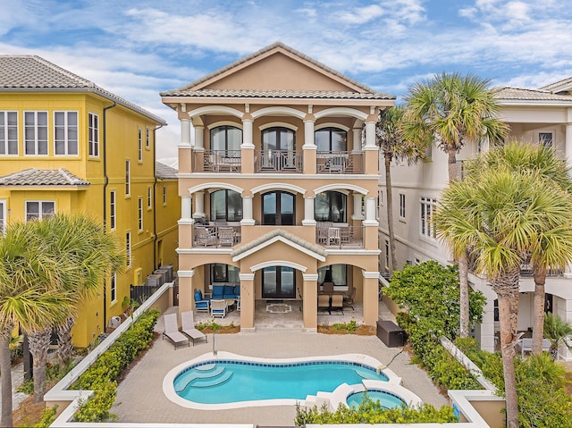 rear view of property featuring a balcony and a patio