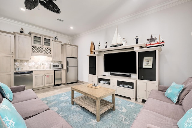 living room with ceiling fan, crown molding, and sink