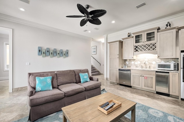 living room with ceiling fan, ornamental molding, and sink