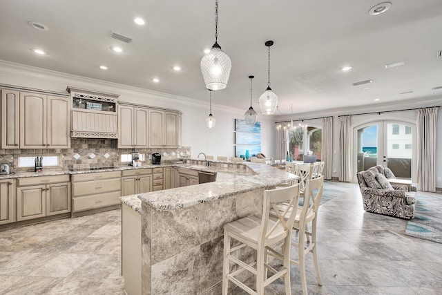 kitchen featuring light stone countertops, tasteful backsplash, decorative light fixtures, a kitchen bar, and kitchen peninsula