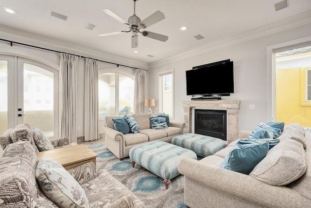 living room featuring a premium fireplace, ceiling fan, and ornamental molding