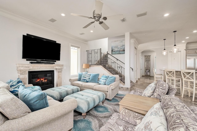 living room featuring crown molding, light hardwood / wood-style flooring, and ceiling fan